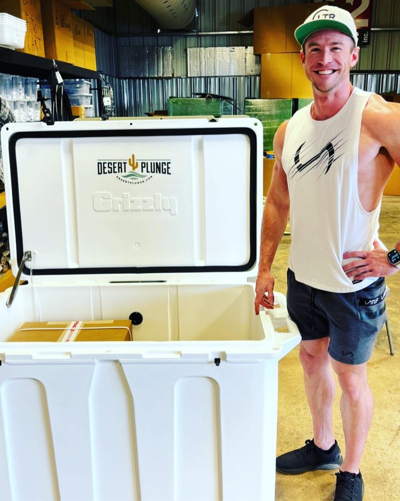 A photo of a  customer posing with his new cold plunge tub from Desert Plunge.