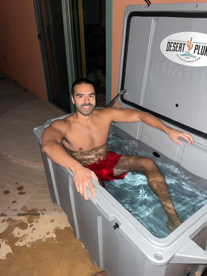 A photo of a happy man enjoying his cold gray plunge tub from Desert Plunge outside on a nice evening.