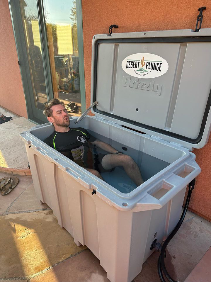 A photo of a man doing cold therapy outside in his cold plunge tub from Desert Plunge.