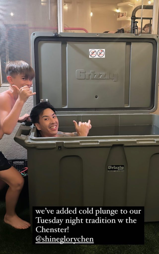 A photo of a man and his son enjoying their cold plunge tub inside from Desert Plunge.