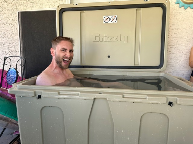 A photo of a man grinning in his cold plunge tub from Desert Plunge.