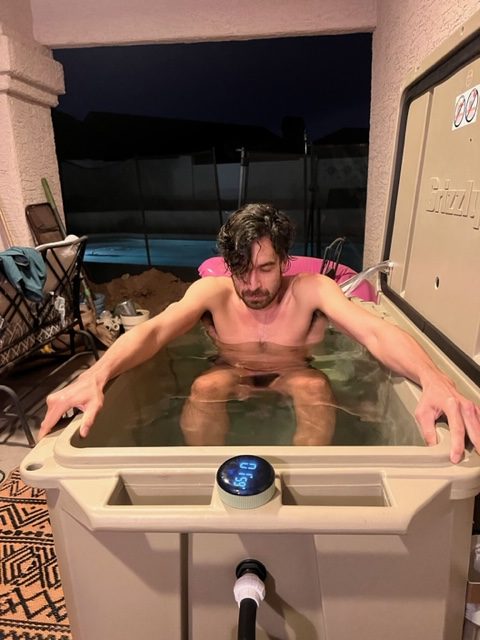 A photo of a man concentrating during cold therapy in his tan cold plunge tub from Desert Plunge.