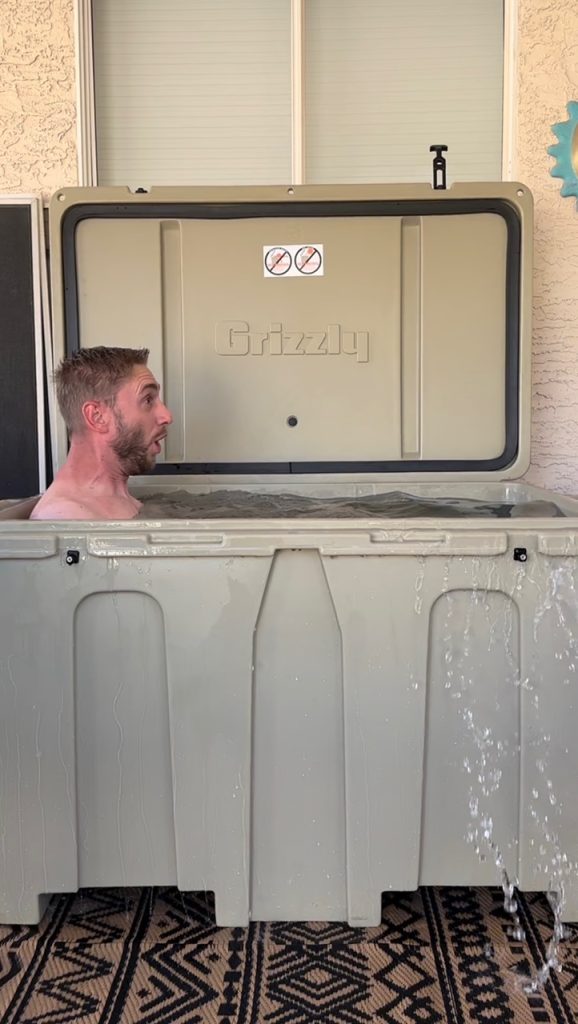 A photo of a man enjoying cold therapy in his tan cold plunge tub from Desert Plunge.
