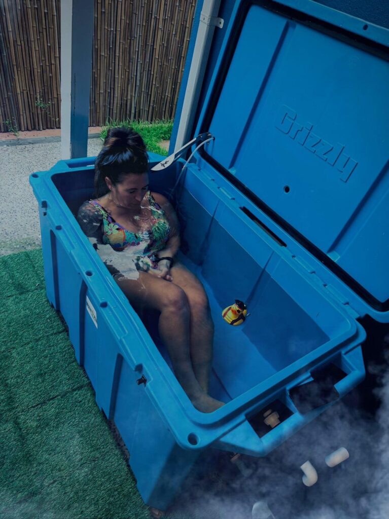 a woman enjoying a cold plunge with rubber duckie in a Desert Plunge Cold Plunge tub