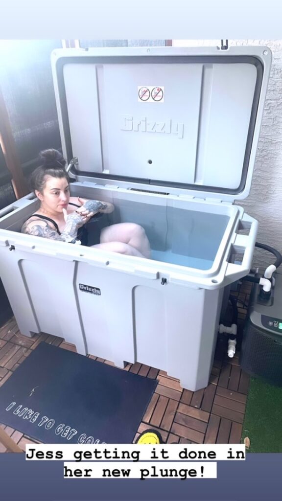 A woman enjoying her gray cold plunge tub from Desert Plunge.