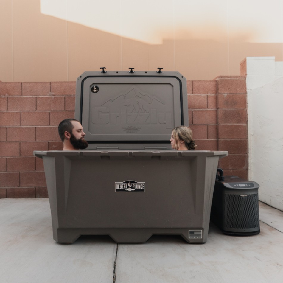 A man and woman together in a Desert Plunge 450 Wide Cold Plunge on a patio deck.